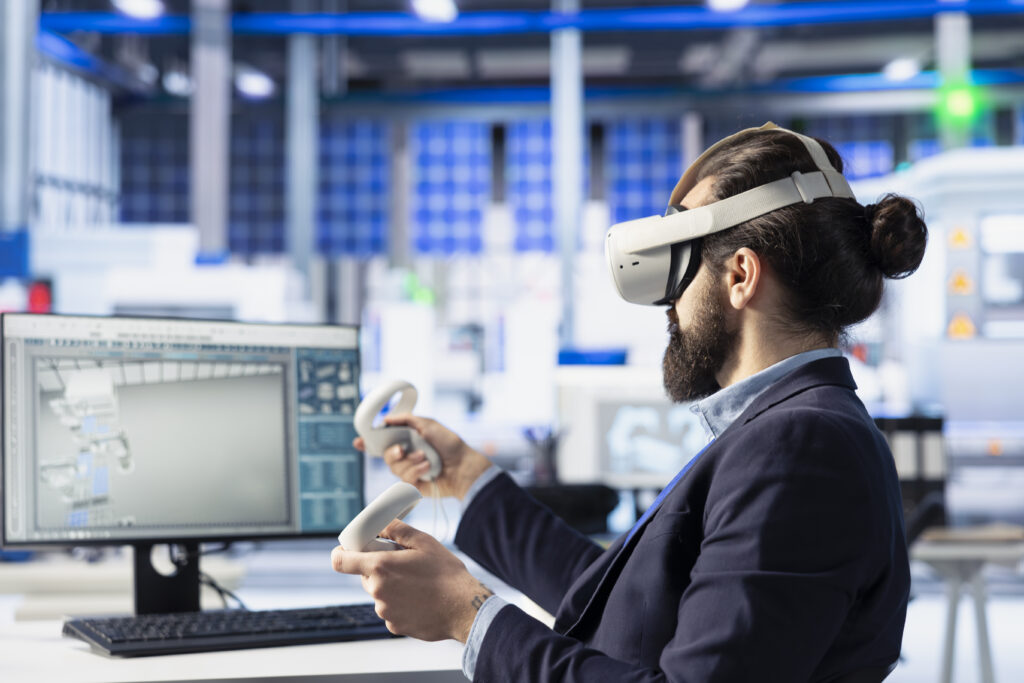 An engineer in VR manipulating a 3D model on a factory floor